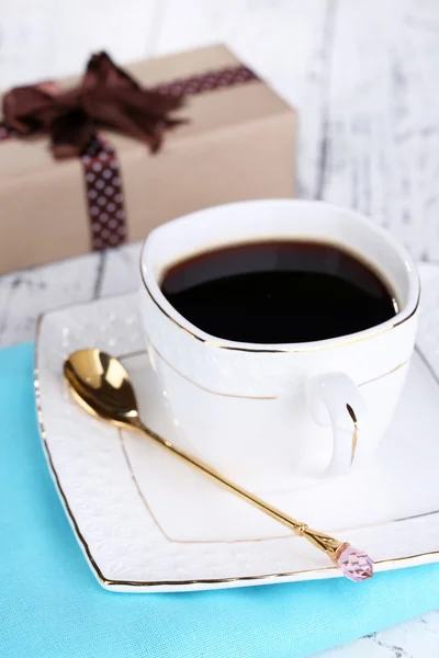 ถ้วยกาแฟและของขวัญบนโต๊ะไม้ — ภาพถ่ายสต็อก
