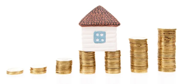 House standing on heap of coins isolated on white — Stock Photo, Image