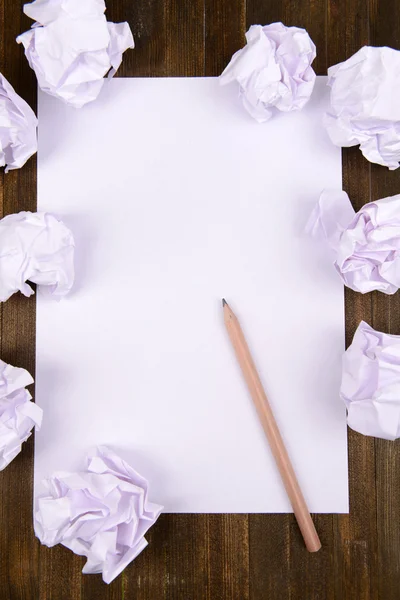 Feuille de papier blanc avec papier froissé et crayon sur table close-up — Photo