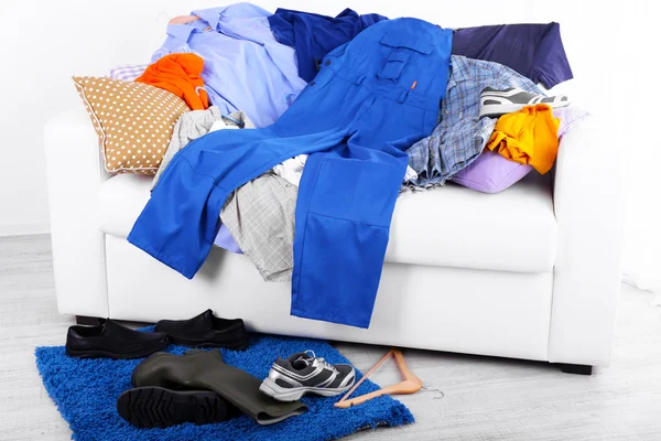 Messy colorful male clothing on  sofa on light background — Stock Photo, Image