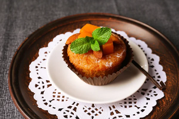 Leckerer Kürbis-Muffin auf grauer Tischdecke — Stockfoto