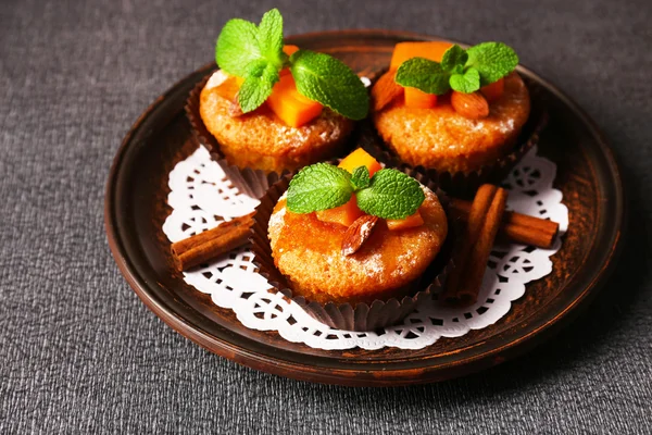 Tasty pumpkin muffins on grey tablecloth — Stock Photo, Image