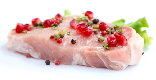 Raw meat steak with leaf lettuce, spices and pomegranate seeds, isolated on white — Stock Photo, Image