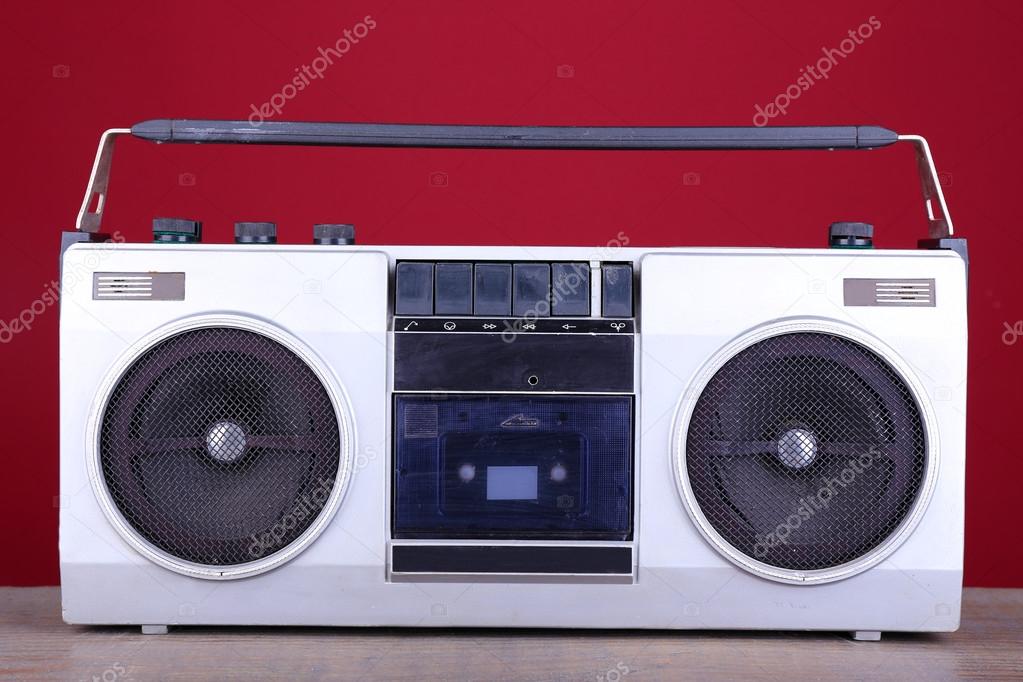 Retro cassette stereo recorder on table on red background