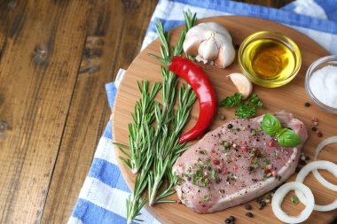 Otlar ve baharatlar ahşap arka plan üzerinde kesme tahtası üzerinde çiğ et biftek