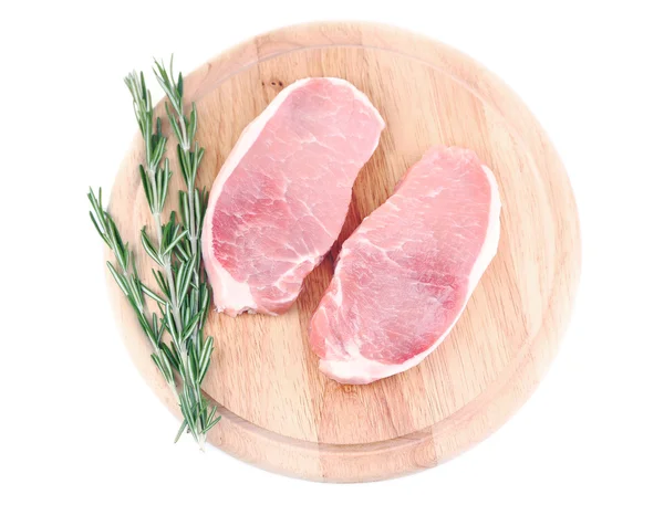 Çiğ et biftek üzerine beyaz izole kesme tahtası üzerinde otlar ile — Stok fotoğraf