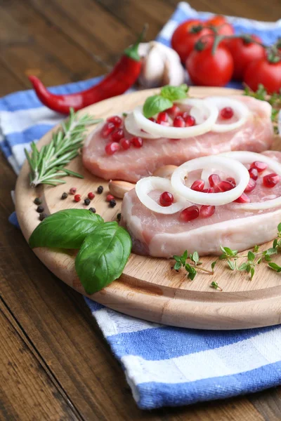 Raw meat steak with herbs and spices on cutting board, on wooden background — Stock Photo, Image