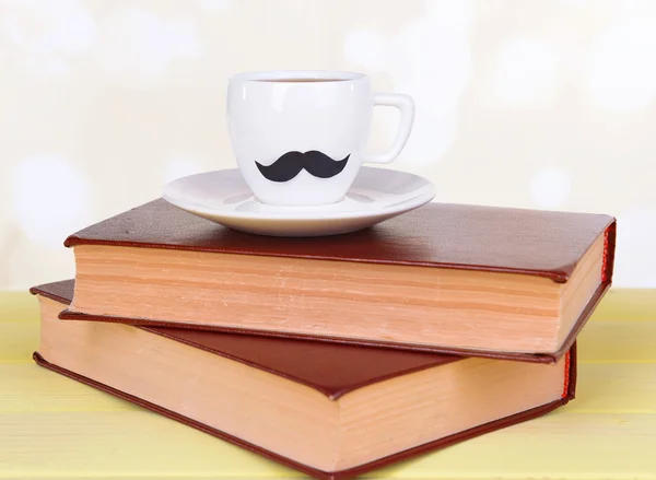 Tasse mit Schnurrbart auf Tisch auf hellem Hintergrund — Stockfoto