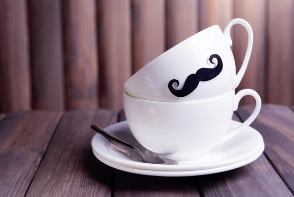 Coupe avec moustache sur table sur fond en bois — Photo