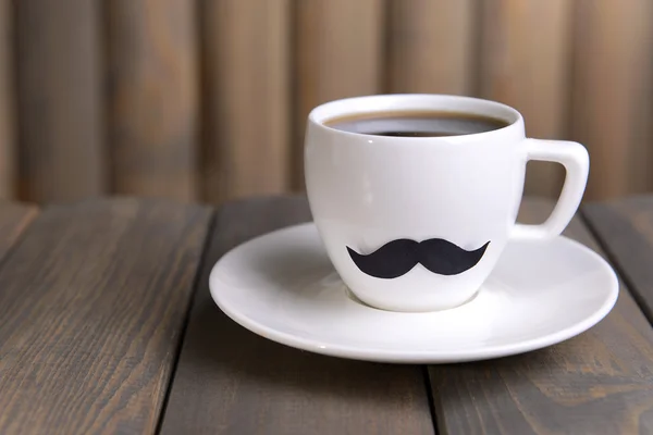 Cup with mustache on table on wooden background — Stock Photo, Image