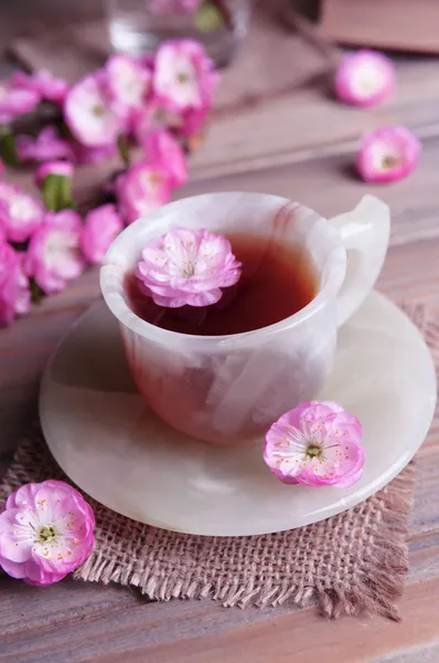 美丽的果实花朵以杯茶上灰色背景表格 — 图库照片