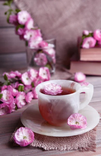 美丽的果实花朵以杯茶上灰色背景表格 — 图库照片