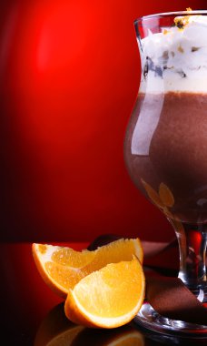 koyu renk arka plan üzerinde çikolata, krema ve portakal soslu lezzetli tatlı