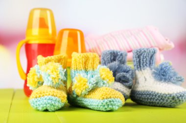 tığ işi patik bebek, elbise, şişe üzerinde ahşap arka plan ile kompozisyon