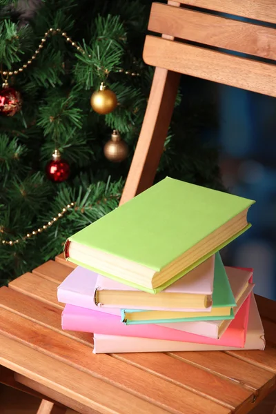 Composição com livros em cadeira no fundo da árvore de Natal — Fotografia de Stock