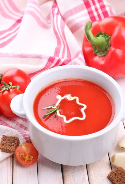 Tasty tomato soup and vegetables on wooden table — Stockfoto
