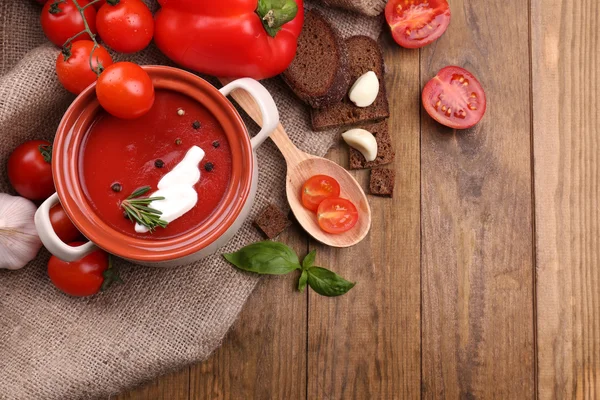 Tasty tomato soup and vegetables on wooden table — Stock Photo, Image