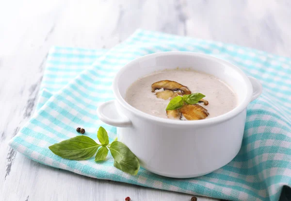 Pilzsuppe im weißen Topf, auf Serviette, auf Holzgrund — Stockfoto