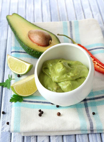 Fresh guacamole in bowl on wooden table — Stock Photo, Image