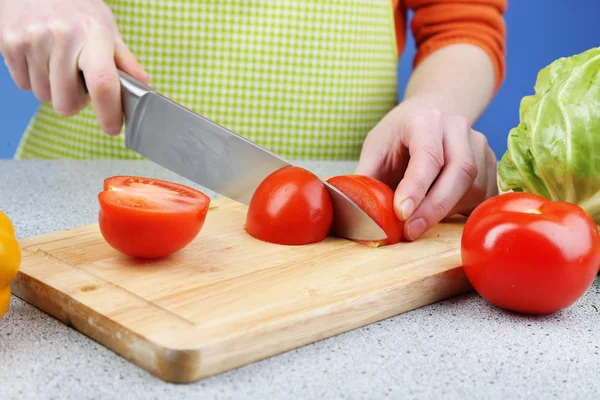 Tangan wanita memotong tomat di papan kayu, close-up — Stok Foto