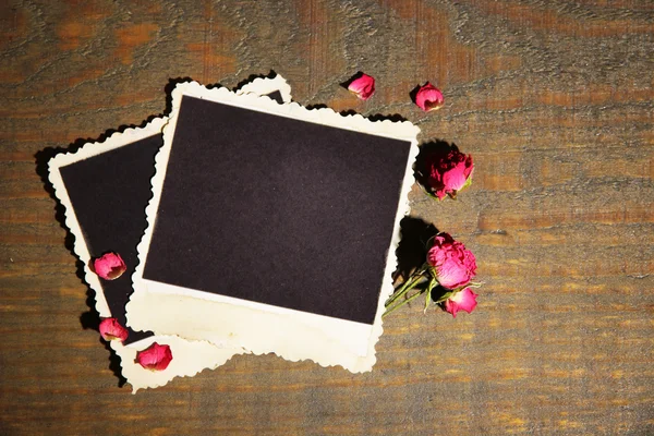 Papel fotográfico en blanco y hermosas rosas secas rosadas sobre fondo de madera —  Fotos de Stock