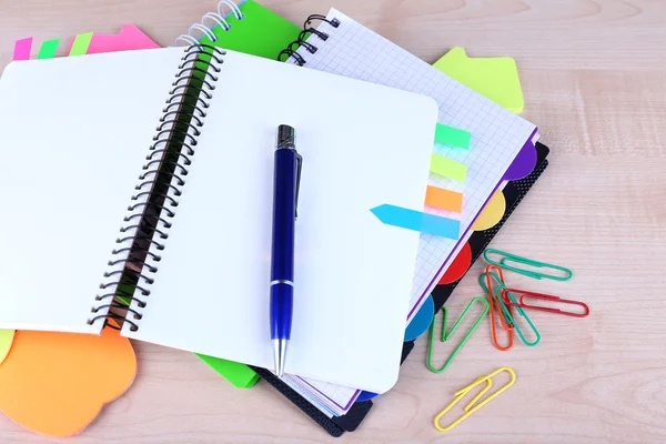 Cuaderno, bolígrafo y pegatinas sobre fondo de madera — Foto de Stock