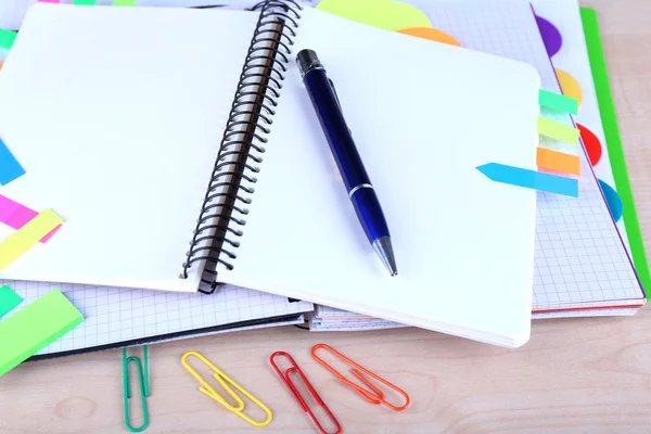 Cuaderno, bolígrafo y pegatinas sobre fondo de madera — Foto de Stock