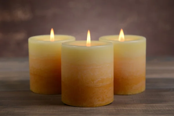 Hermosas velas en la mesa sobre fondo marrón —  Fotos de Stock