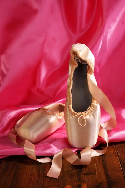 Zapatos de punto de ballet en piso de madera sobre fondo de tela — Foto de Stock