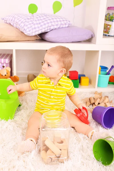 Söt liten pojke med trä leksak blockerar i rum — Stockfoto