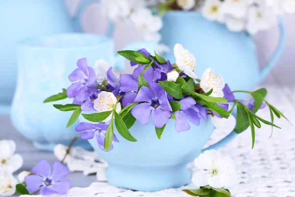 Piękne wiosenne kwiaty w kubki na drewnianym stole — Zdjęcie stockowe