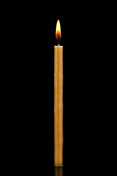 Палаюча свічка на чорному фоні — стокове фото