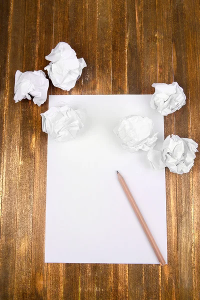 Hoja de papel blanco con papel arrugado y lápiz en primer plano de la mesa — Foto de Stock