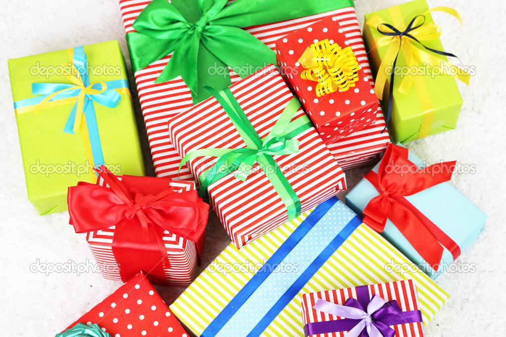 Many colorful presents with luxury ribbons  on color carpet background