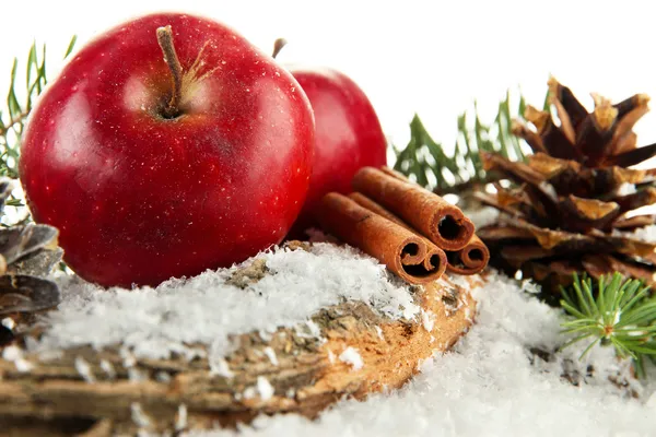 Rote Äpfel mit Tannenzweigen auf Rinde im Schnee aus nächster Nähe — Stockfoto