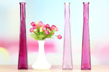 açık renkli raf üzerinde farklı dekoratif vazolar