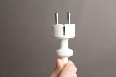 el elektrik fişi gri arka plan üzerinde tutarak