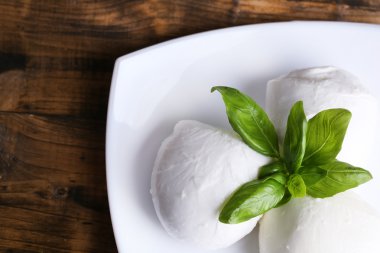 lezzetli mozzarella peyniri Fesleğenli ahşap zemin üzerinde plaka üzerinde
