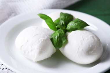lezzetli mozzarella peyniri Fesleğenli ahşap zemin üzerinde plaka üzerinde
