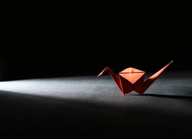 ışık ile karanlık arka plan üzerinde Origami turna