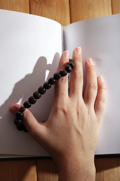 Руки с четками и святой книги, на светлом фоне — стоковое фото