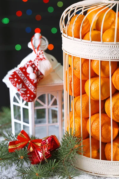 Tangerinas em gaiola decorativa com decoração de Natal, em fundo brilhante — Fotografia de Stock