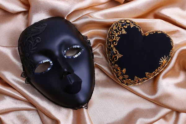 Decorative black heart and mask, on color fabric — Stock Photo, Image