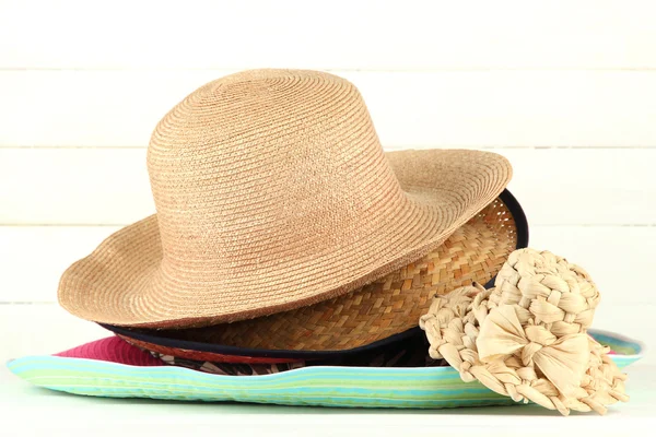 Beaucoup de chapeaux sur la table sur fond clair — Photo