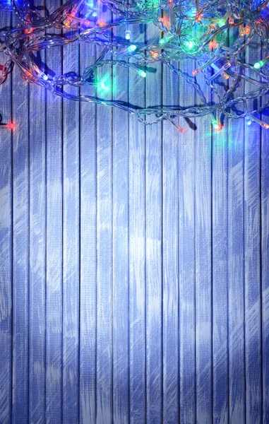 Christmas lights on wooden background — Stock Photo, Image