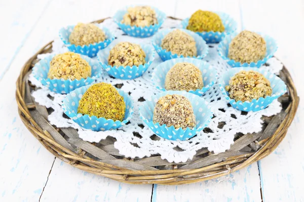 Set van chocolade snoepjes, op rieten mat, op houten achtergrond — Stockfoto