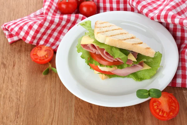 Leckeres Sandwich mit Schinken auf Holztisch — Stockfoto