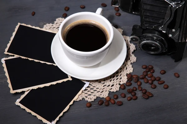 Coffee cup, vintage camera and old blank photos, on wooden background — Stock Photo, Image