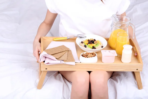 Junge schöne Frau im Bett mit leichtem Frühstück — Stockfoto