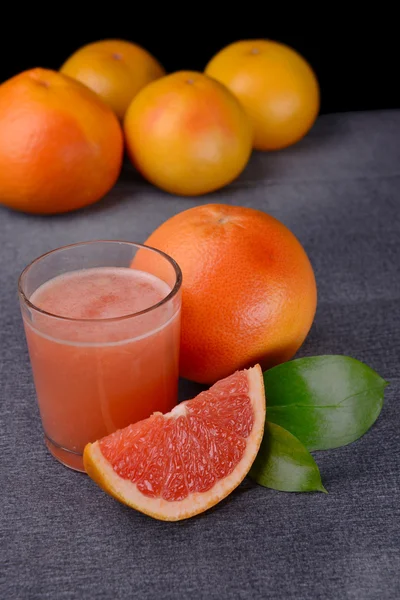 Zralý grapefruit s džusem na stole zblízka — Stock fotografie